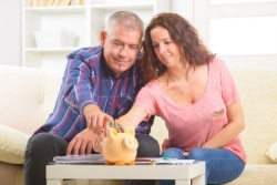 זוג יושב ומכניס כסף לקופת החסכון שלו